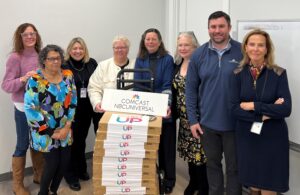 group of people with a stack of laptops